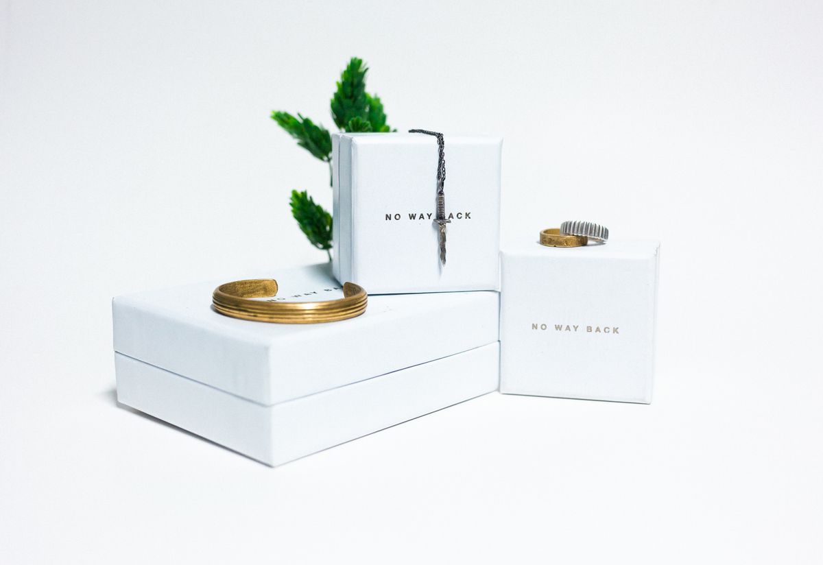 Gold plated silver medallion jewelry displayed on a white box