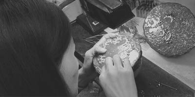 Jeweler setting zircon stones into a 925 sterling silver ring