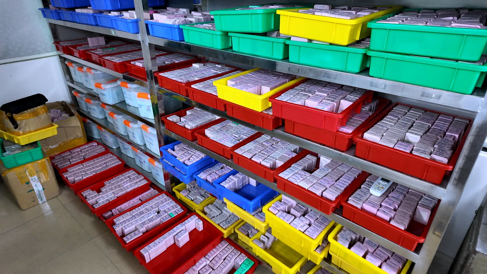 Component stock stored in labelled trays on workshop shelving