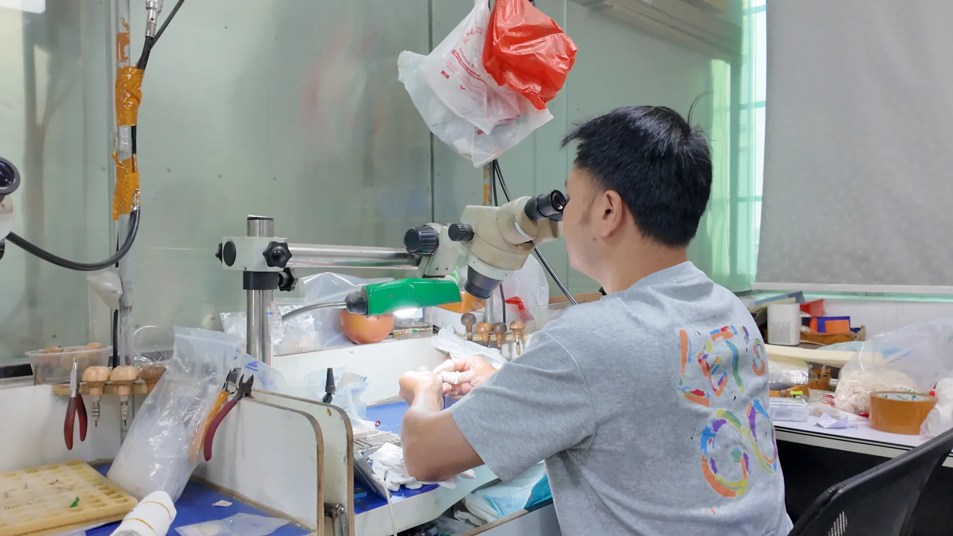 Inspector checking a jewelry piece under a stereo microscope