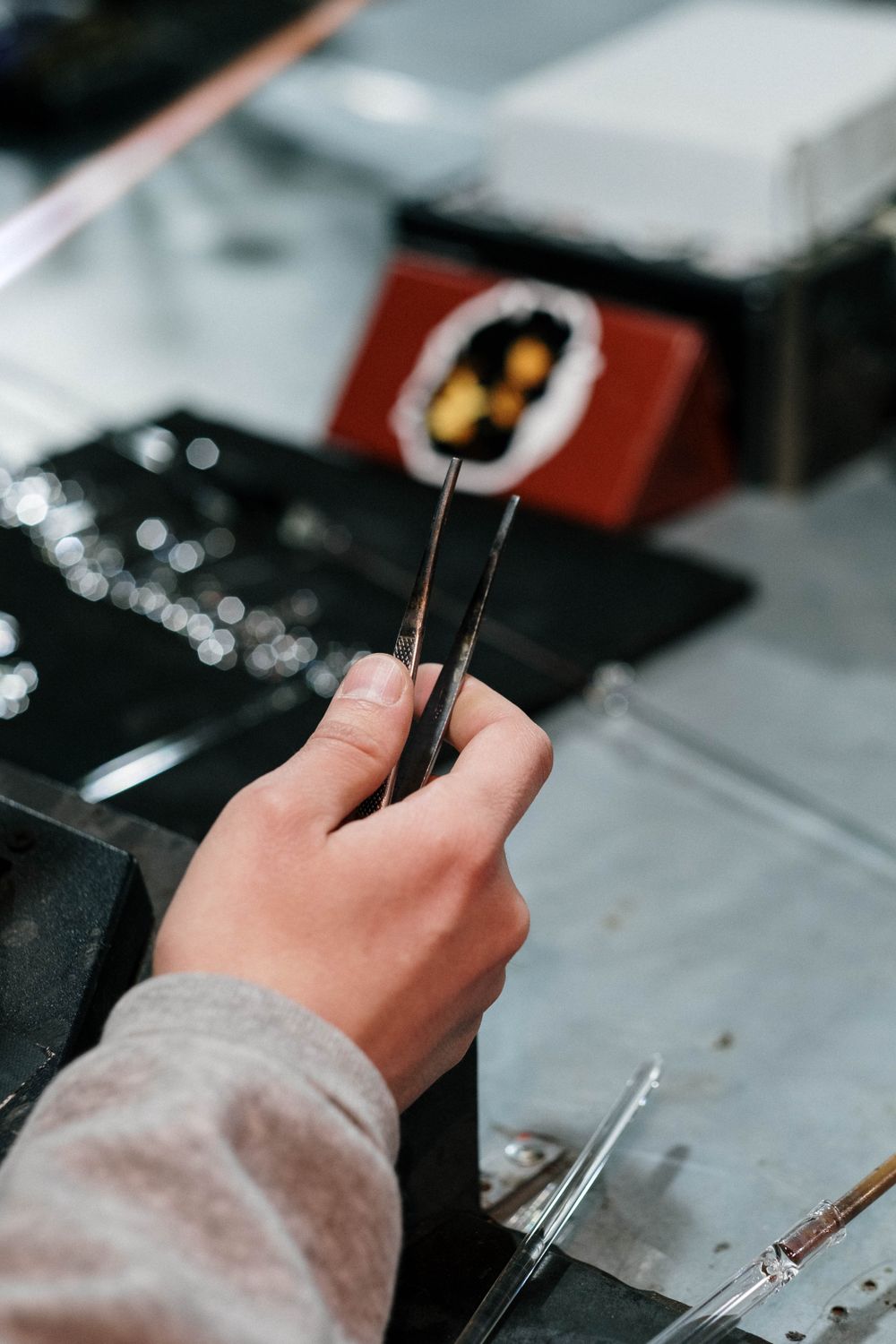 Quality inspection of a 925 sterling silver jewelry piece held with tweezers
